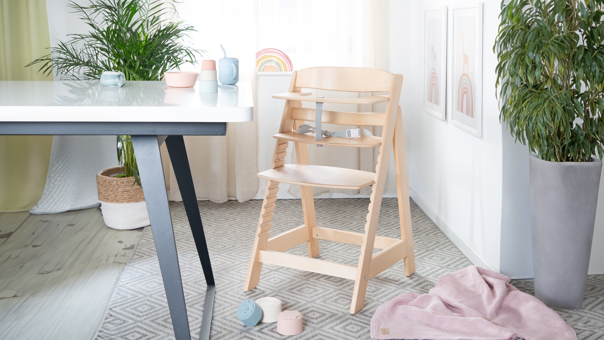 Treppenhochstuhl mit liegendem Baby aus Holz in der Farbe weiß