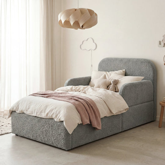 Lit enfant gris en bouclé avec protection antichute, coussin, peluche et veilleuse nuage dans une chambre d'enfant. Entièrement générée par IA.