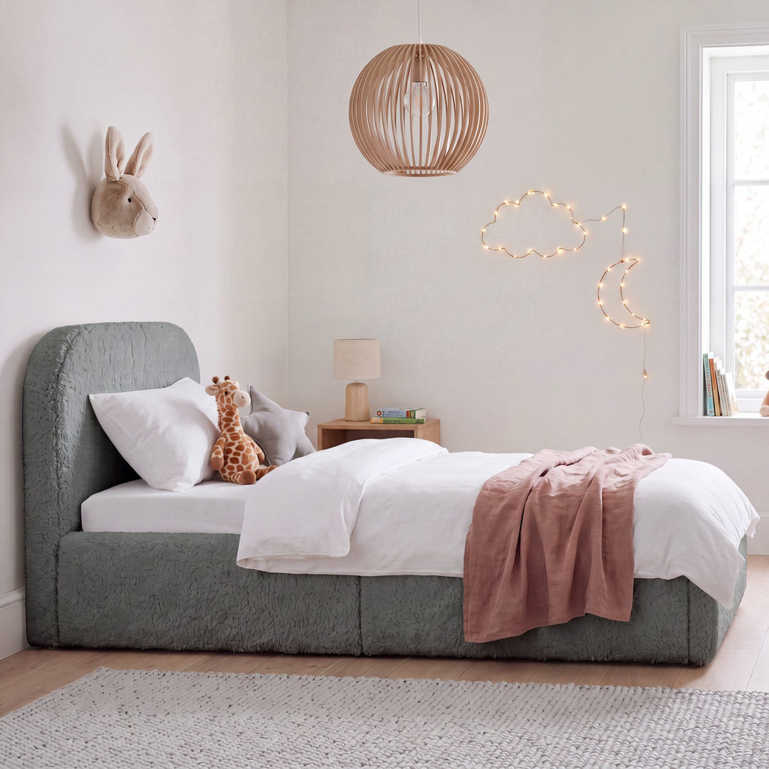 Lit enfant gris en bouclé avec protection antichute, peluches et lampe en bois dans une chambre d'enfant. Entièrement générée par IA.