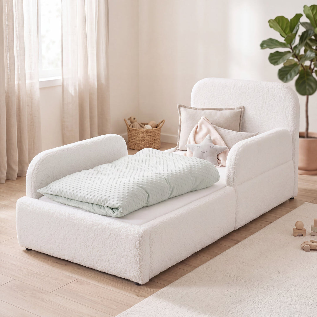 Lit enfant blanc en bouclé avec protection antichute, panier en rotin et plante dans une chambre lumineuse. Entièrement générée par IA.