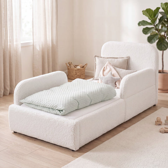Lit enfant blanc en bouclé avec protection antichute, panier en rotin et plante dans une chambre lumineuse. Entièrement générée par IA.