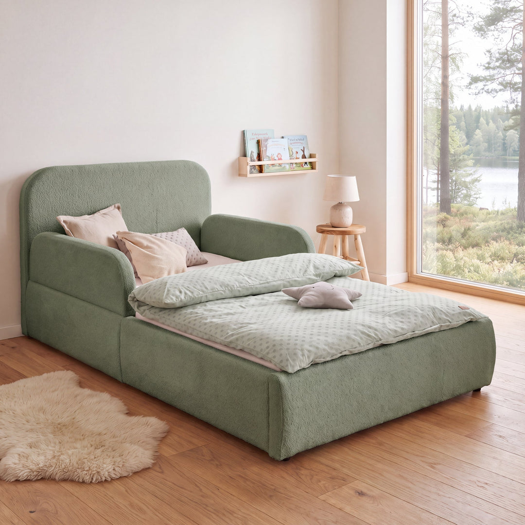 Lit enfant roba Little Dream vert dans une chambre d'enfant avec vue sur le lac, bibliothèque et tapis en peau de mouton. Entièrement générée par IA.