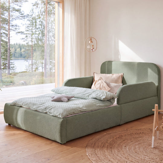 Lit enfant roba Little Dream vert dans une chambre d'enfant avec vue sur le lac et mobile suspendu au-dessus du lit. Entièrement générée par IA.