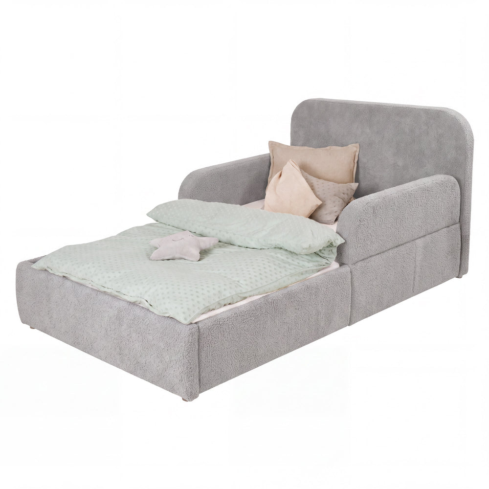 Lit enfant roba Little Dream gris clair avec tête de lit et protections latérales, garni de linge de lit et de coussins. Partiellement générée par IA.