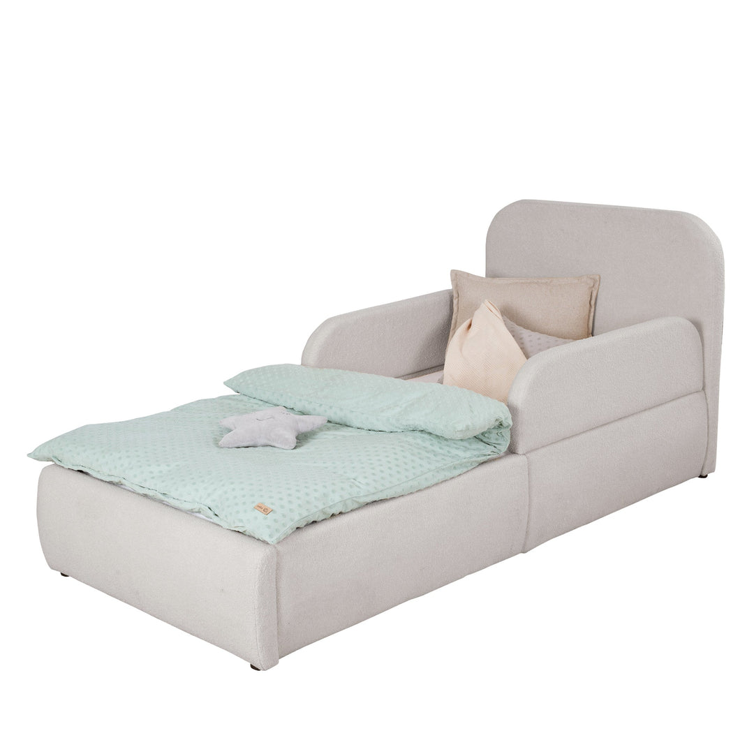 Lit enfant roba Little Dream avec éléments latéraux gris clair montés, garni de linge de lit crème. Partiellement générée par IA.