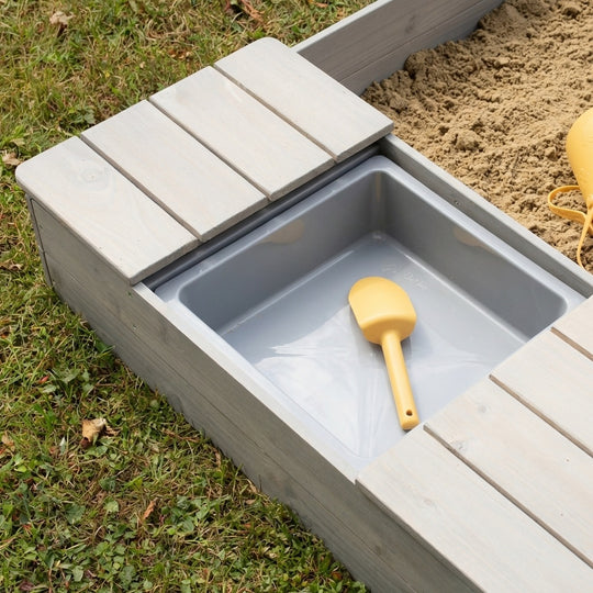 Caja de arena 'Outdoor +' gris lasurada, incluye banco abatible y 2 cubos de juego